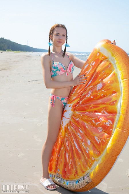 Молодая девушка Нести надевает бикини, чтобы позировать обнаженной с заплетенными косичками на пляже