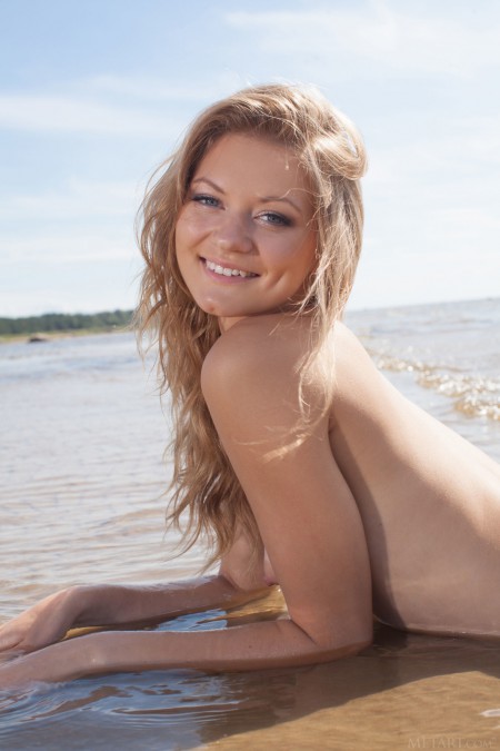 Smiling blonde  in a white t-shirt on the shore