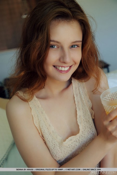 Young redhead Sienna wakes up before showing her bald pussy on her bed